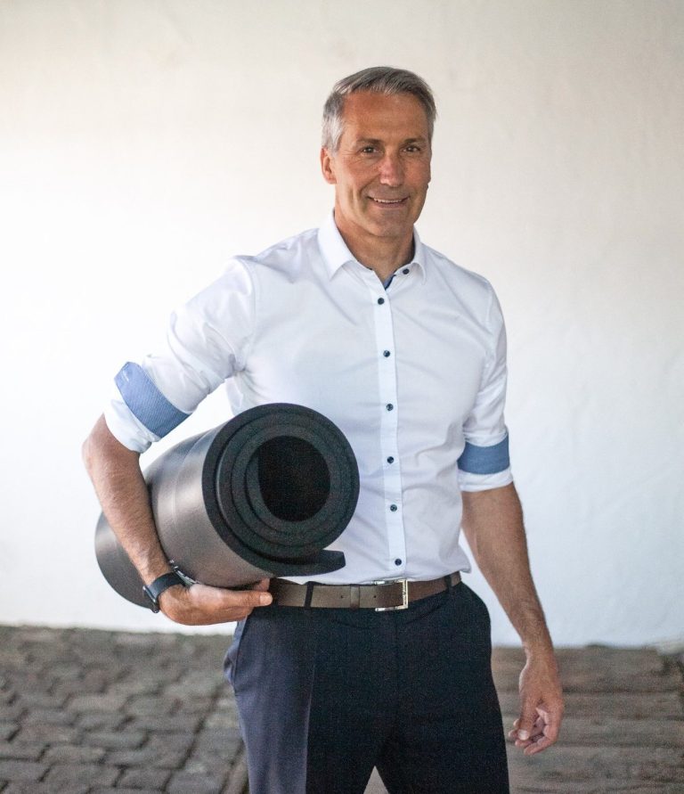 Business man carrying a fitness mat